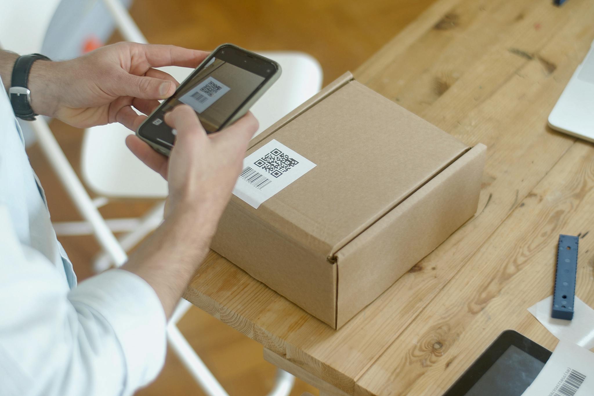 How to Make a QR Code for Website Link – Free QR Generator 3 A person uses a smartphone to scan a QR code on a package in an online store setting.
