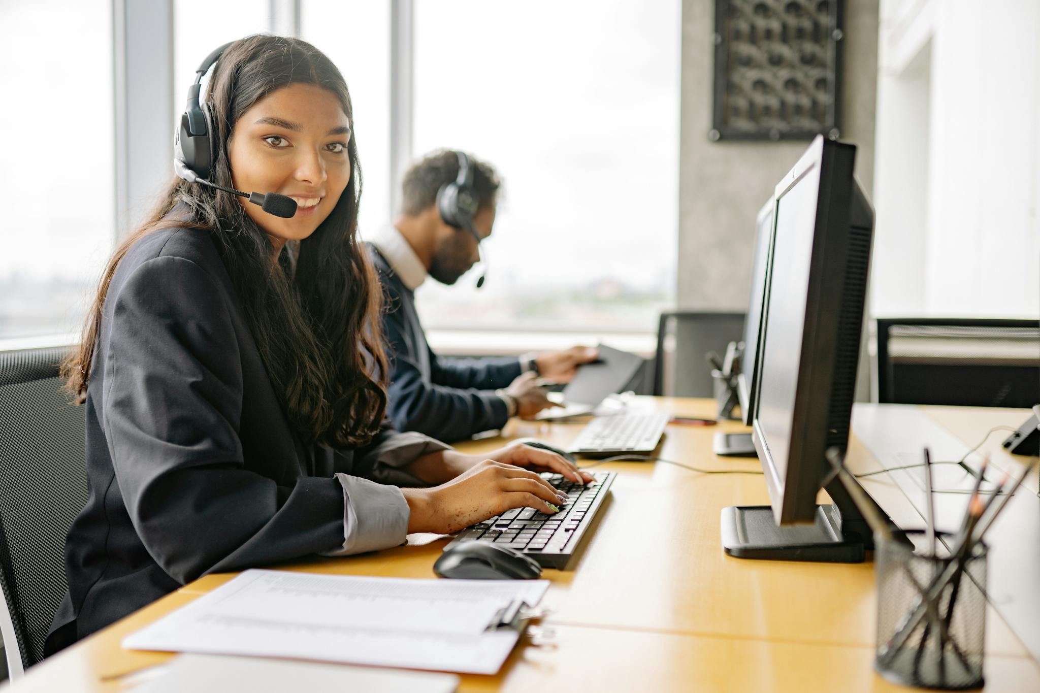 How to Generate a QR Code For Phone Number - Free QR Code 4 Smiling call center agents in an office providing customer support on computers.